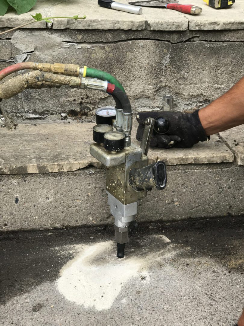 Mudjacking Foam Injection Repair for Concrete Cement Sidewalk Concrete leveling with industrial drilling machine.