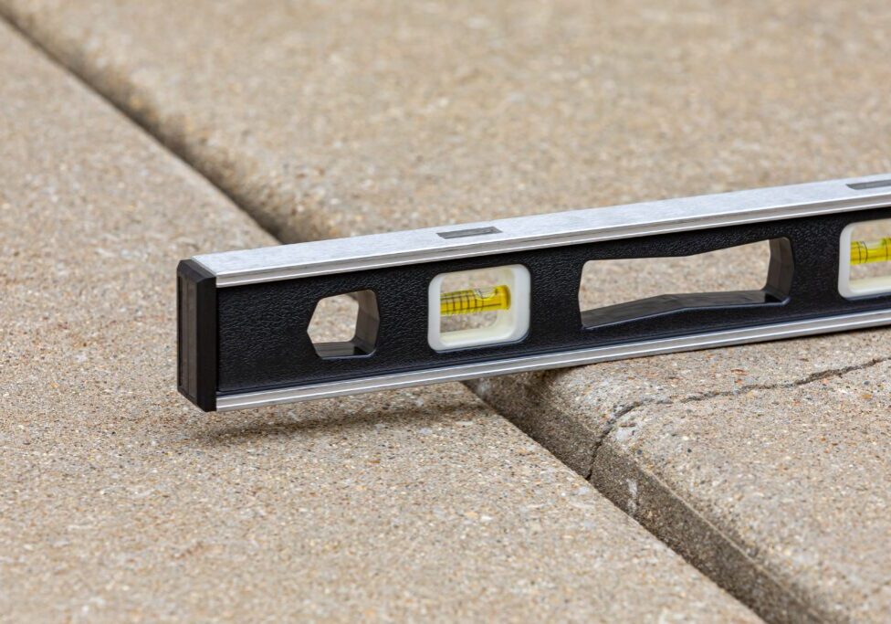Level tool on uneven concrete surface.